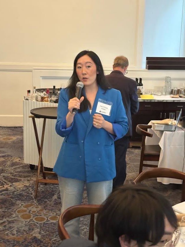A woman speaking into a microphone during a BDI event